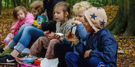 Børn spiser madpakke i skoven