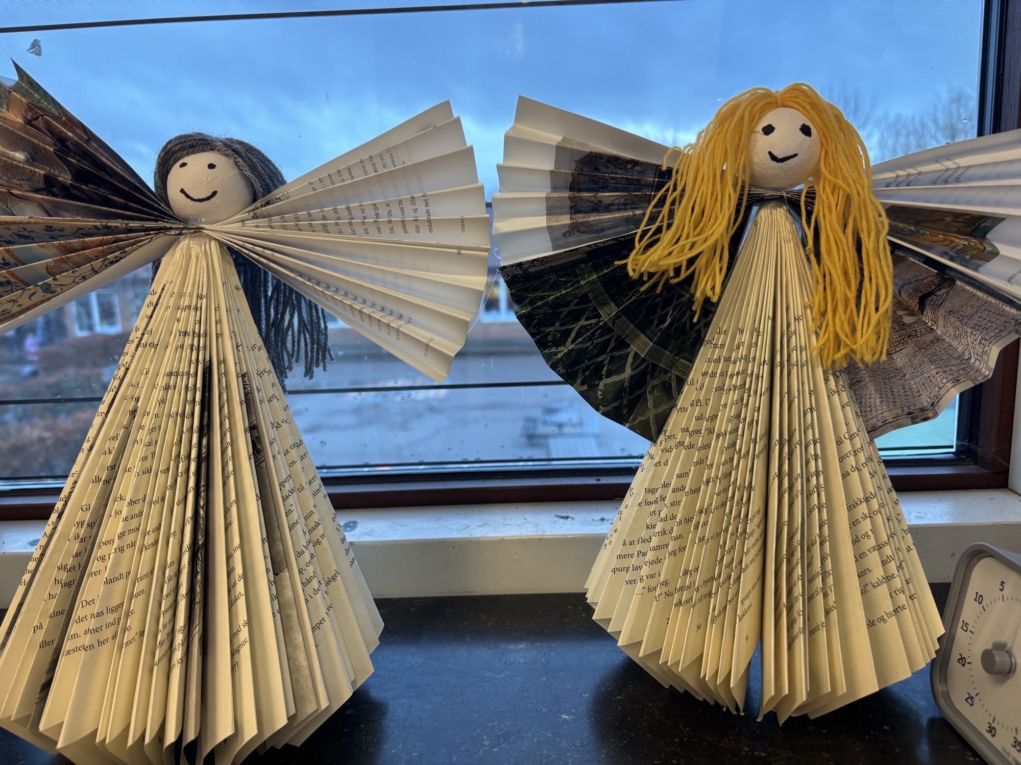 Håndlavede papirengle i en vindueskarm