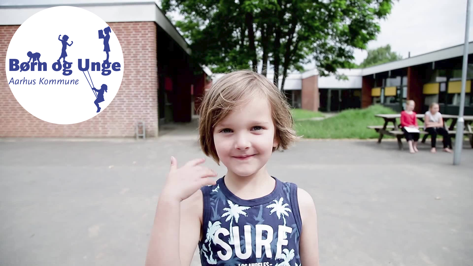 Barn foran en skole + Børn og Unge logo