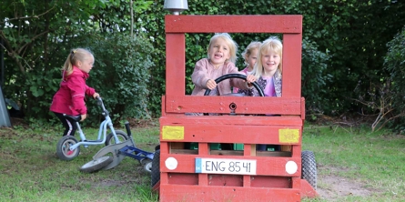 Børn i legebil udenfor